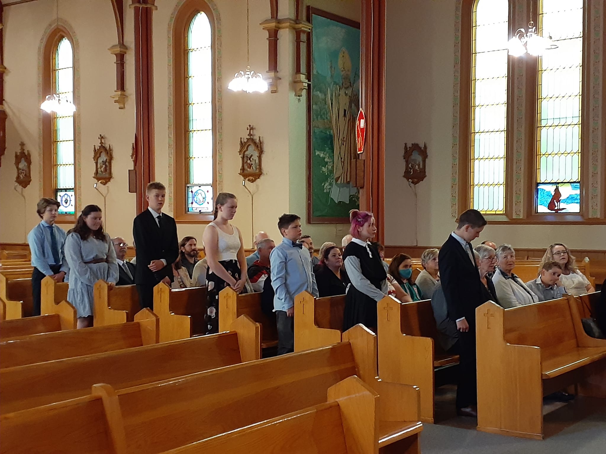 confirmation 2022- children standing in pews renewing baptismal promises
